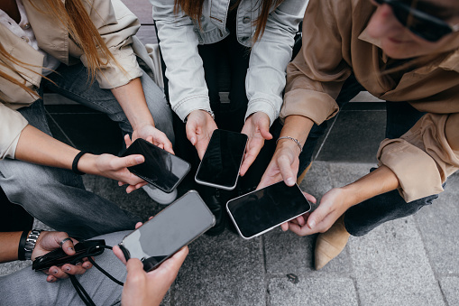 Close up of people using mobile smart phones - Detail of friends sharing photos on social media network with smartphone - Technology concept