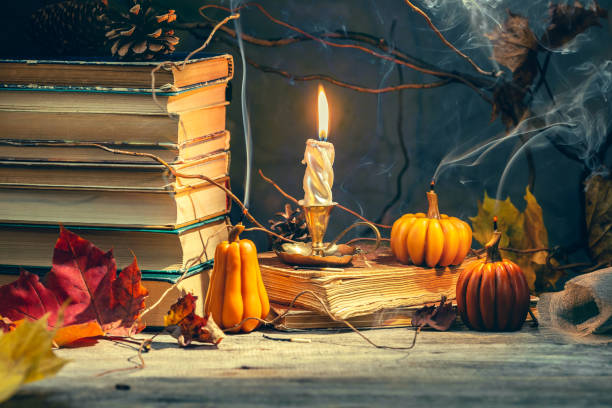 istock Old antique books with pumpkin shape candles 1346876129
