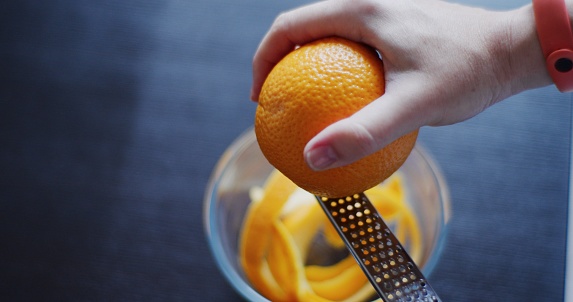 Female hands are preparing orange zest for food