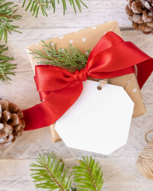 istock Christmas present with blank gift tag top view, Mockup 1346877302