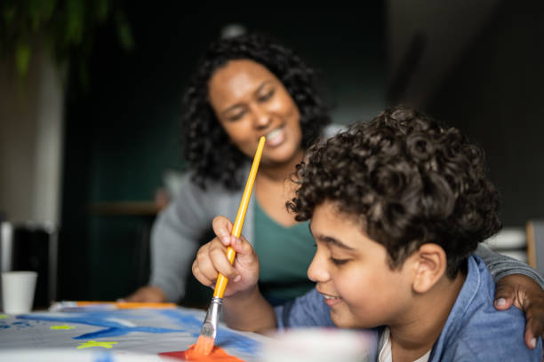 istock Mother help son drawing at home 1346878400