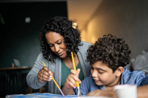 istock Mother help son drawing at home 1346878422