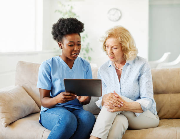 istock nurse doctor senior care tablet computer technology showing caregiver help assistence retirement home nursing elderly woman african american black happy laughing 1346880553