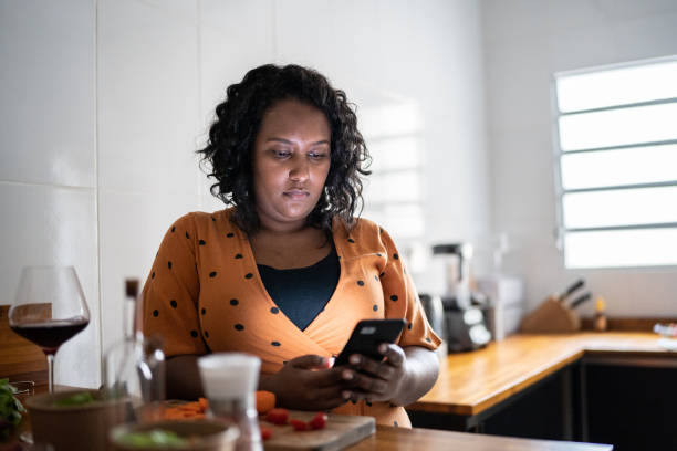 istock Mid adult woman using smartphone at home 1346880742