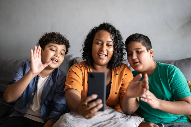 istock Mother and son on a video call using smartphone at home 1346880762