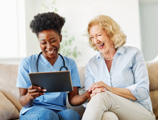 istock nurse doctor senior care tablet computer technology showing caregiver help assistence retirement home nursing elderly woman african american black happy laughing 1346880763