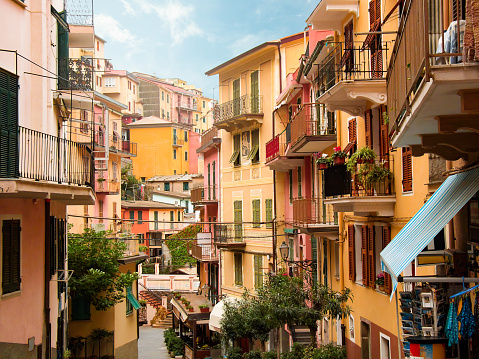 Charming colourful houses overlook the street and alley in Manarola a picturesque village in the Cinque Terre, Italy. This famous UNESCO site is popular with tourists.