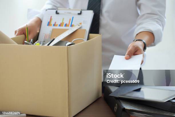 Resignation Businessman Has A Brown Cardboard Box Next To His Body And Sends A Letter Of Resignation To The Employer Boss Resignation Letter Staff Reduction Resigning Leaving The Office Stock Photo - Download Image Now
