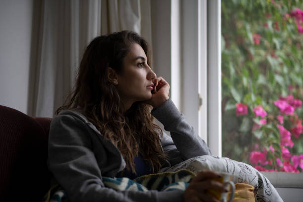 Depressed Woman Sitting by Window