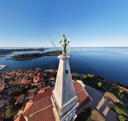 Close-up aerial view of statue of Saint Euphemia (15th century) on top of bell tower in old town Rovinj. Istria, Croatia.