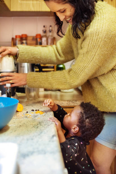 istock Smiling mom watching her daughter eat raisins while preparing lunch 1346885133