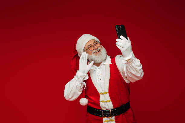 istock Happy, real, funny Santa Claus using smart phone 1346887962