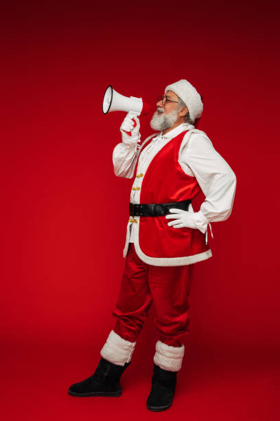 Happy, real, funny Santa Claus holding a megaphone