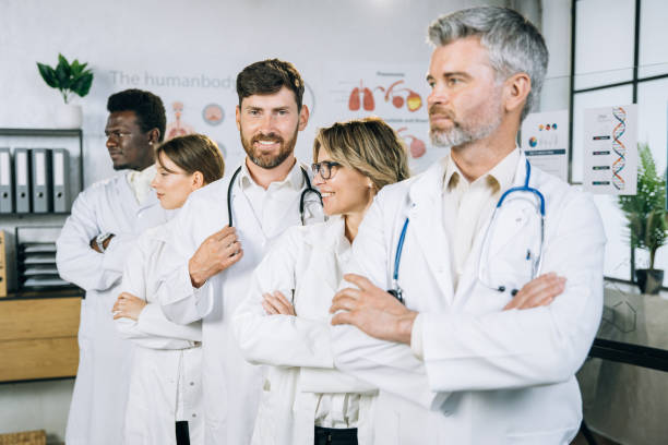 istock Mixed race medical specialists standing in row at office 1346890631