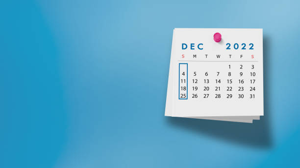 dezember kalender 2022 auf notizblock vor blauem hintergrund - dezember stock-fotos und bilder