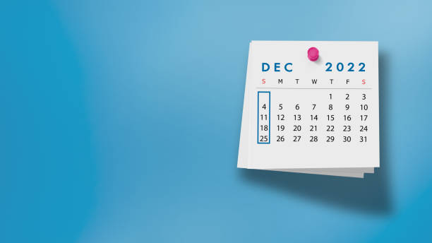2022 December Calendar on Note Pad Against Blue Background 2022 December calendar on a white note paper pinned on wall against blue background. High resolution and copy space for all your crop needs. december stock pictures, royalty-free photos & images
