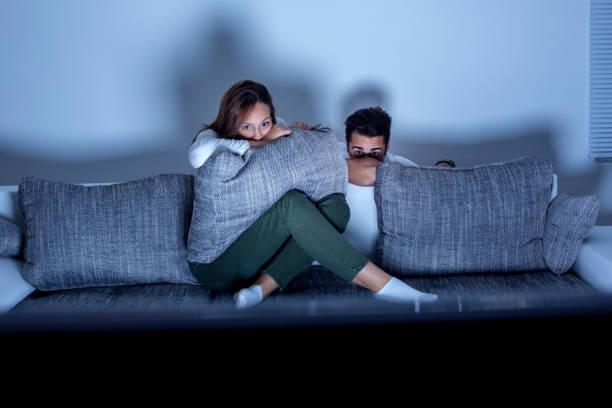 couple watching a horror movie - negatief beeldtype stockfoto's en -beelden