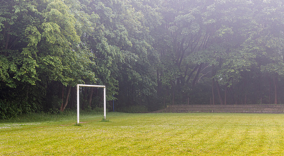 Empty goal in the field on the grass in the park in the fog. Horizontal header banner copy space blog background