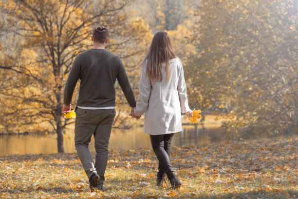istock Young couple walking in the park during autumn 1346907521