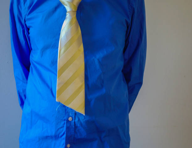 Close-up of a businessman's blue tie on dark pinstripe suit with modern glass architecture in the background
