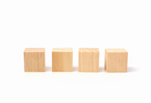 four empty geometric wooden cube blocks isolated on a white background.