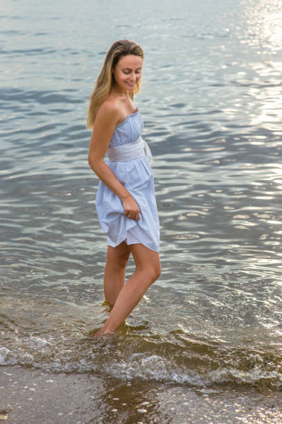 istock Young woman standing on water, looking around, thinking 1346914109