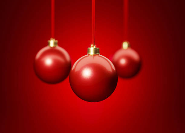 Three red Christmas hanging over red background. Christmas and festivity concept. Horizontal composition with selective focus and copy space.