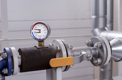 Manometer and thermometer for measuring the temperature and pressure of water in the plumbing system at a gas boiler room.
