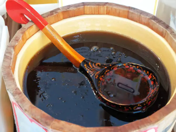 Buckwheat honey in a wooden keg with a ladle in the Khokhloma style.