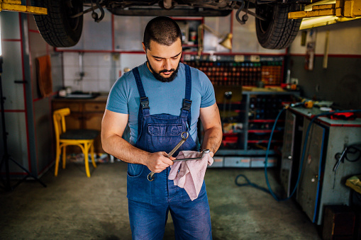 Mechanic cleaning his tools after servicing a car at his auto repair shop