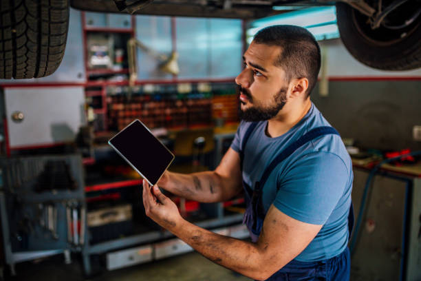 istock Car mechanic using tablet in auto repair shop 1346917100
