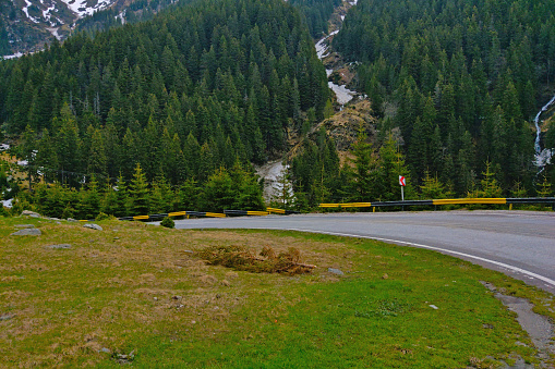 Picturesque mountain winding road against the background of a green forest.