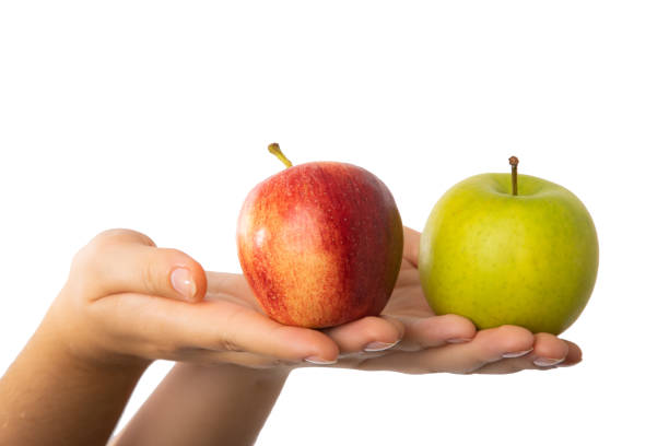 istock Red and green apple held in female hands. 1346921277