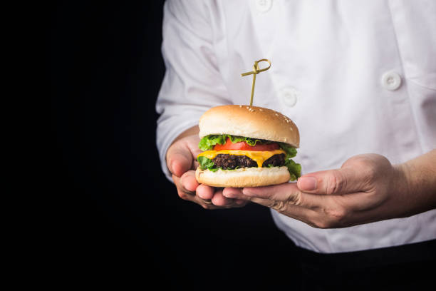 istock A cook holds a delicious beef hamburger just made 1346927914