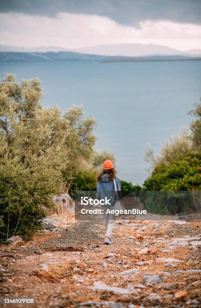 Young Woman Walking To The Sea Stock Photo - Download Image Now - Walking, Nature, One Woman Only