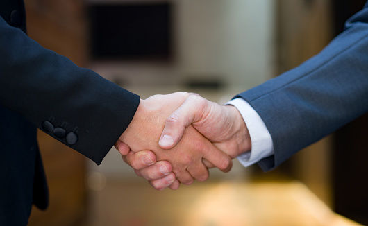 Close-up on business people closing a deal with a handshake - success concepts