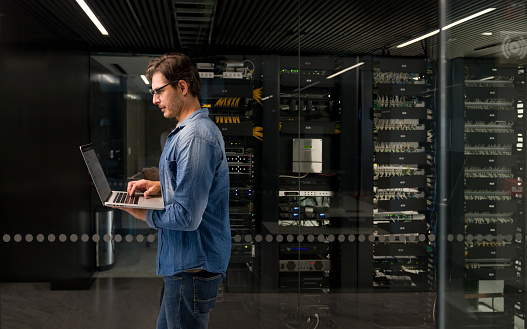 IT technician fixing a problem on a network server at an office building â technology concepts