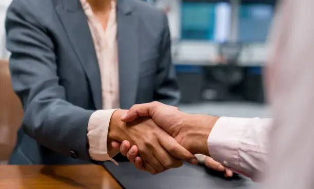 Close-up on business people closing a deal with a handshake at the office