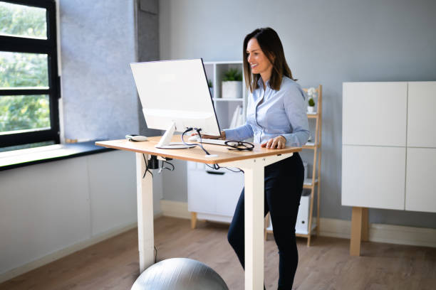istock Woman Using Adjustable Height Standing Desk In Office 1346931506
