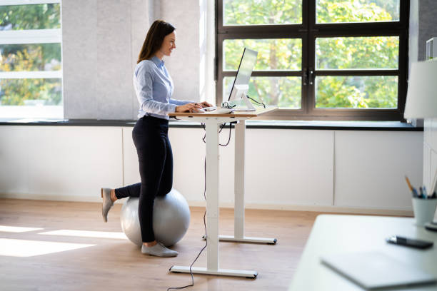 istock Woman Using Adjustable Height Standing Desk In Office 1346931524