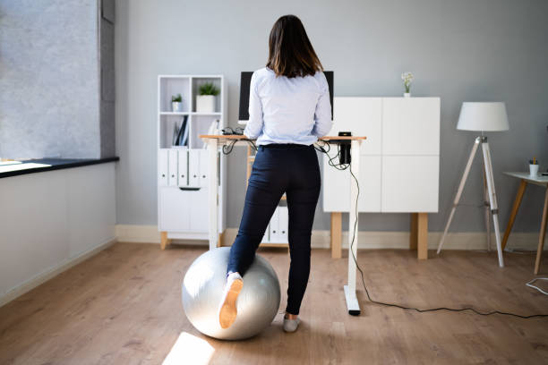 istock Woman Using Adjustable Height Standing Desk In Office 1346931526