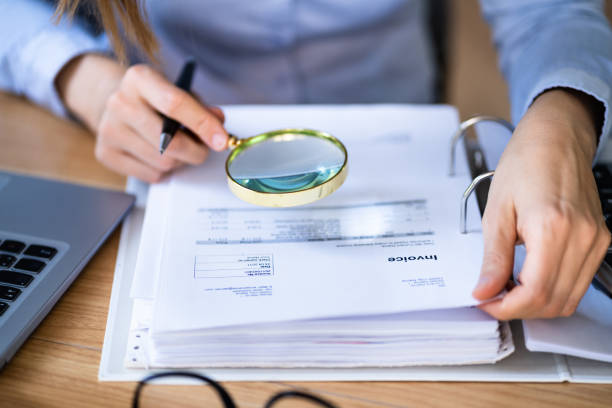 istock Lawyer Examining Invoice Using Magnifier Glass 1346931586