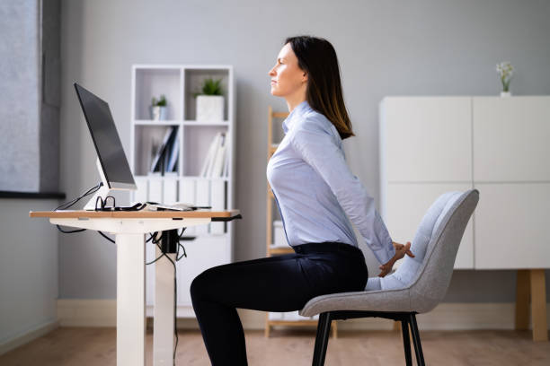 istock Woman Stretching Arms At Office Desk 1346931611