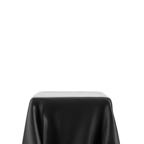 istock Empty spotlight pedestal covered with black cloth isolated on white 1346931718