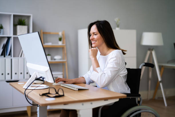 istock Person With Disability In Wheelchair Working 1346931728