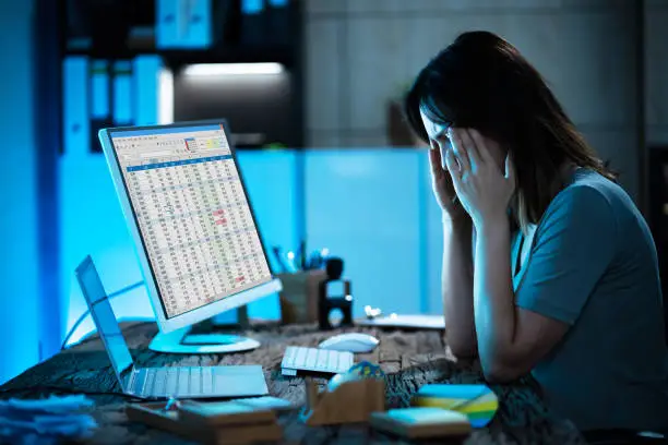 Photo of Bored Stressed Accountant Working Late