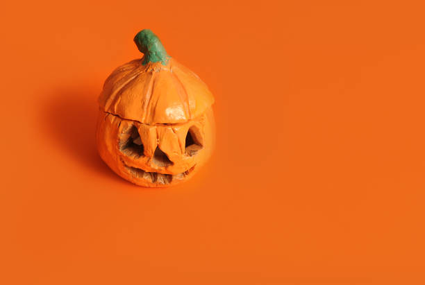 istock Hand made halloween pumpkins on orange background. 1346933189