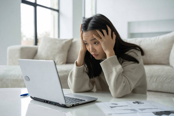 istock Tired, exhausted Asian woman with a laptop, problems with the project, feeling depressed, laziness in the home office in the living room 1346938524