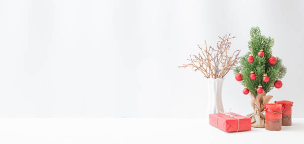 istock Christmas, New Year home decor. Christmas tree, gift box, golden branches on a light background. Mock up for displaying works 1346938959