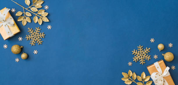 istock Christmas holiday banner background with copyspace. Flat lay frame with christmas balls and gift box on a blue background 1346938973